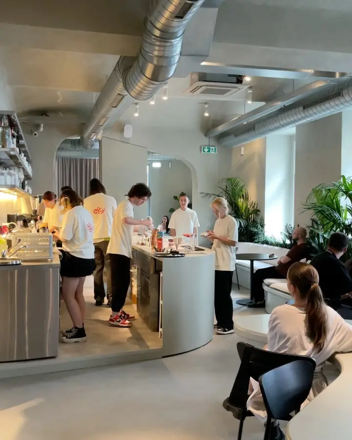 The main hall of EFSY — sage-green organic counter, plants and the team at work