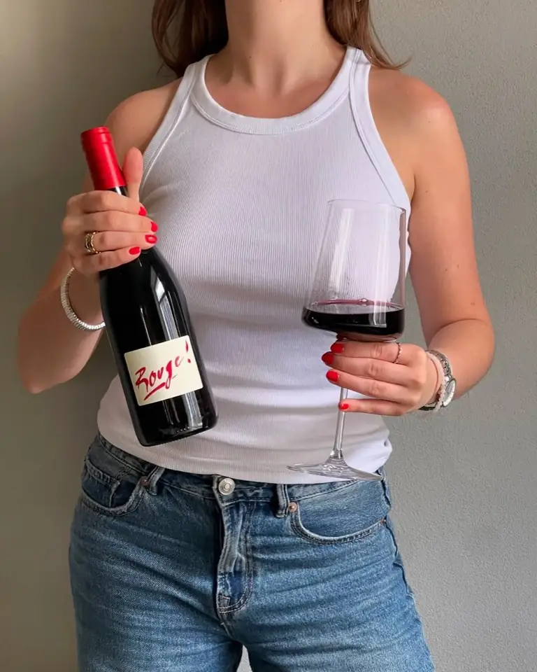 A glass of red wine and a bottle of Rouge!